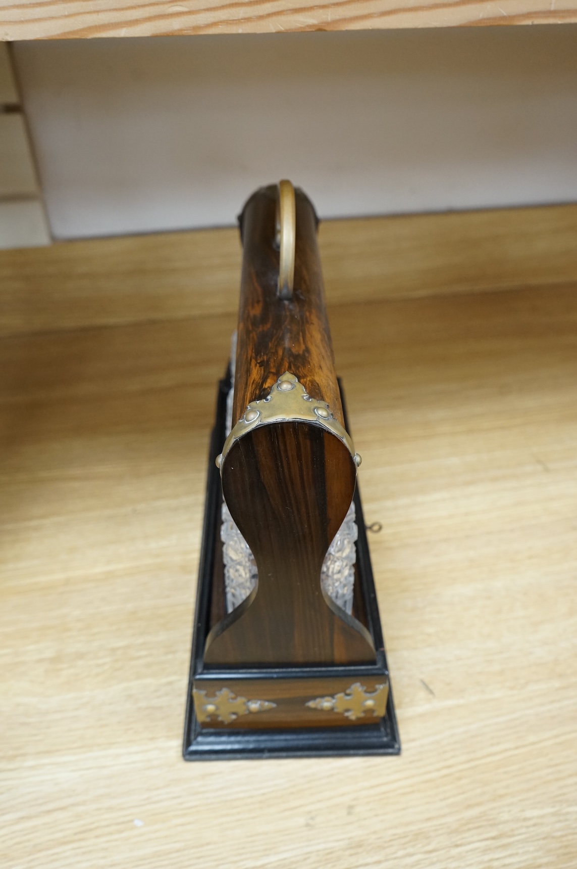 A Victorian coromandel three-bottle tantalus with brass mounts and original key